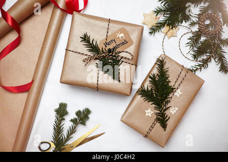 Cadeaux de Noël enveloppé dans du papier brun, décoré de Fern et string, overhead view Banque D'Images