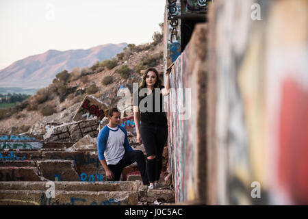 Jeune homme et femme à la découverte de l'écriture graffiti des murs à ruiné la mienne Banque D'Images