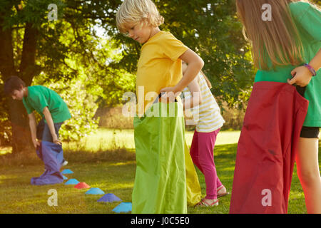 Les filles et les garçons la préparation de sac course sur la ligne de départ dans la région de park Banque D'Images