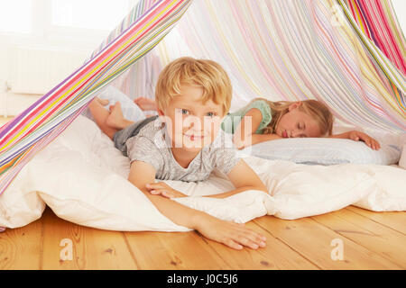 Portrait de jeune garçon et sa sœur se trouvant dans la chambre tente Banque D'Images