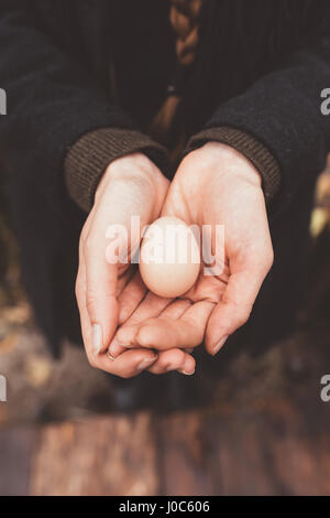 Woman's hands holding egg bombée Banque D'Images