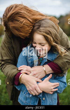 Mother and Daughter hugging in meadow Banque D'Images