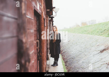 Portrait de jeune femme par weathered hut Banque D'Images