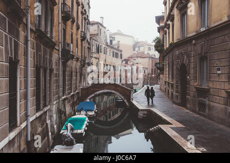 Vue arrière du couple strolling le long canal mer, Venise, Italie Banque D'Images