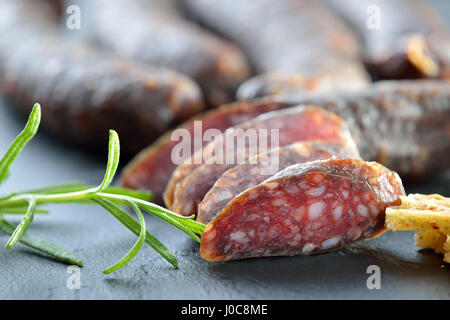 Collation tyrolienne typique du sud avec saucisses (soi-disant) Kaminwurzen et très croustillant de pain plat (soi-disant) Schuettelbrot servi sur une ardoise Banque D'Images