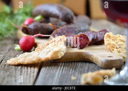 Collation tyrolienne typique du sud avec saucisses ('Kaminwurzen') et le pain plat croustillant (soi-disant) Schuettelbrot, souvent servi avec du vin de la région Banque D'Images