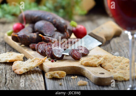 Collation tyrolienne typique du sud avec saucisses ('Kaminwurzen') et le pain plat croustillant (soi-disant) Schuettelbrot, souvent servi avec du vin de la région Banque D'Images