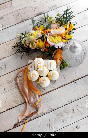 Beaux gâteaux et bouquet de mariée dans les tons orange Banque D'Images