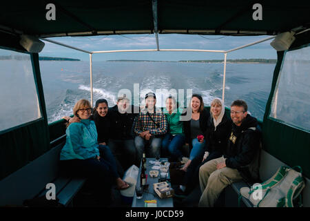 Portrait de famille adultes assis dans le bateau en mer près de la côte du Maine, USA Banque D'Images