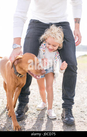 Portrait de jeune fille entre les jambes du père at coast Banque D'Images