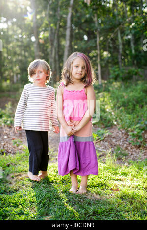 Portrait of boy and Girl standing in garden Banque D'Images