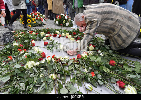 Weimar, Allemagne. Apr 11, 2017. Akexander Bychok, anciennement un détenu du camp de concentration de Buchenwald, s'agenouille sur une plaque commémorative au cours d'une cérémonie marquant le 72e anniversaire de la libération du camp, près de Weimar, Allemagne, 11 avril 2017. Plus de 200 visiteurs se souvint de la libération du camp par une minute de silence a commencé à 15 h 15, heure à laquelle un détachement de soldats américains sont arrivés au camp en 1945. Photo : Martin Schutt/dpa-Zentralbild/dpa/Alamy Live News Banque D'Images