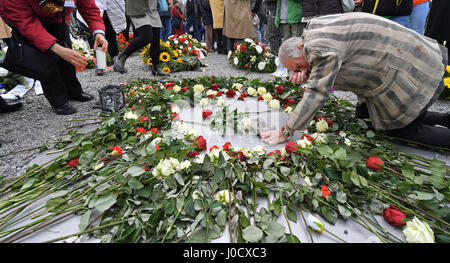 Weimar, Allemagne. Apr 11, 2017. Akexander Bychok, anciennement un détenu du camp de concentration de Buchenwald, s'agenouille sur une plaque commémorative au cours d'une cérémonie marquant le 72e anniversaire de la libération du camp, près de Weimar, Allemagne, 11 avril 2017. Plus de 200 visiteurs se souvint de la libération du camp par une minute de silence a commencé à 15 h 15, heure à laquelle un détachement de soldats américains sont arrivés au camp en 1945. Photo : Martin Schutt/dpa-Zentralbild/dpa/Alamy Live News Banque D'Images