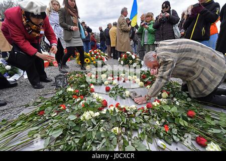 Weimar, Allemagne. Apr 11, 2017. Akexander Bychok, anciennement un détenu du camp de concentration de Buchenwald, s'agenouille sur une plaque commémorative au cours d'une cérémonie marquant le 72e anniversaire de la libération du camp, près de Weimar, Allemagne, 11 avril 2017. Plus de 200 visiteurs se souvint de la libération du camp par une minute de silence a commencé à 15 h 15, heure à laquelle un détachement de soldats américains sont arrivés au camp en 1945. Photo : Martin Schutt/dpa-Zentralbild/dpa/Alamy Live News Banque D'Images