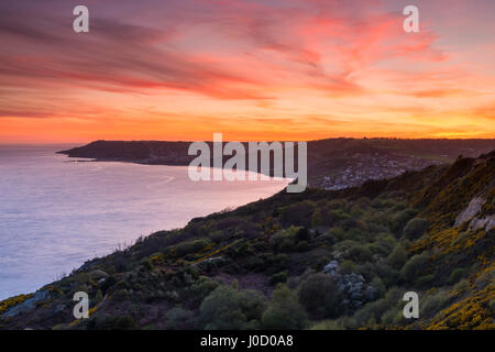 Charmouth, Dorset, UK. Apr 11, 2017. Météo britannique. Un spectaculaire coucher de soleil vu du South West Coast Path sur Stonebarrow Hill à l'ouest en direction de Charmouth et Lyme Regis dans le Dorset. Crédit photo : Graham Hunt/Alamy Live News Banque D'Images