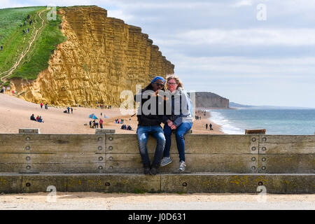 West Bay, Dorset, UK. 12 avr, 2017. Météo britannique. Les vacanciers sur le quai en prenant un en face de selfies falaise est rendu célèbre par l'ITV crime drama Broadchurch un jour de pluies et vents frisquets de West Bay, dans le Dorset. Crédit photo : Graham Hunt/Alamy Live News Banque D'Images