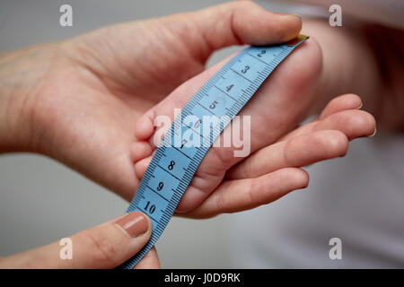 Close up of hands avec ruban de mesure baby foot Banque D'Images