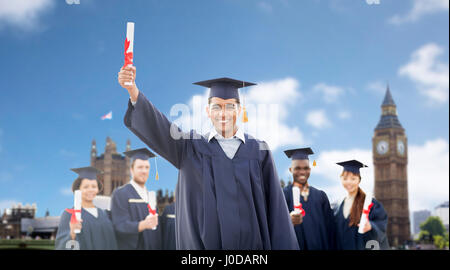 Les élèves heureux dans mortarboards avec diplômes Banque D'Images