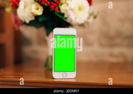 Un livre blanc smartphone avec un écran vert, et un bouquet de mariée de Banque D'Images