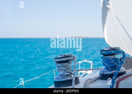 La voile sur une mer bleu calme. Des lignes, câbles, treuils, voiles et gréement sur le pont d'un voilier aux Bahamas. Banque D'Images