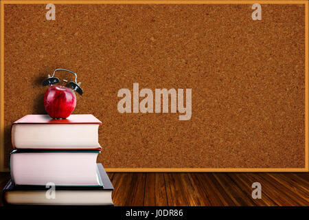 Une pomme rouge avec alarme sur une pile de livres. Le temps de retourner à l'école, conception de l'apprentissage, l'enseignement, l'alphabétisation. Copie de l'espace sur panneau backgroun Banque D'Images
