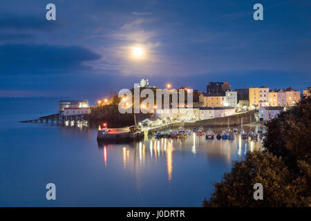 Le 'Pink' Avril pleine lune s'élève au-dessus d'un paisible port de Tenby à marée haute. Dans Pembrokeshire Wales Banque D'Images