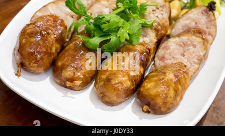 Les délicieuses saucisses thaïlandaises fermentées (Sai Krok ISAN) du nord-est de la Thaïlande sur plaque blanche. Banque D'Images