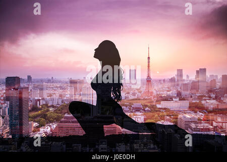 Double exposition de Silhouette yoga woman contre la ville de Tokyo au coucher du soleil Banque D'Images