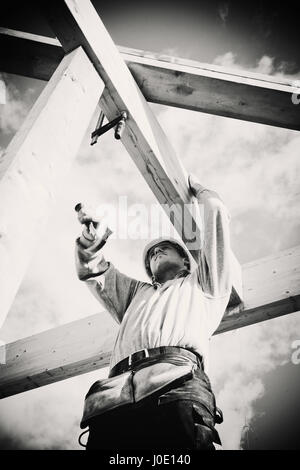 Avec un marteau de charpentier travaillant sur la construction en bois. Monochrome Banque D'Images