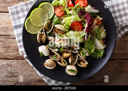 Palourdes fines avec de la chaux et de la salade de légumes frais sur une plaque. Vue du dessus horizontale Banque D'Images