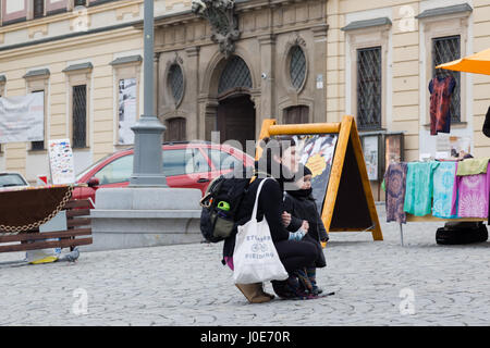 Jeune mère célibataire avec enfant fille écouter street musician sur marché dans Brno, République Tchèque Banque D'Images