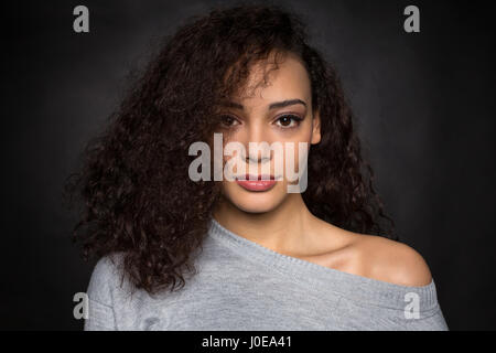 Jeune femme avec des cheveux bouclés dans chandail gris, portrait, Mode, mode de vie Banque D'Images
