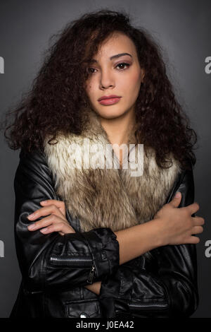 Jeune femme avec des cheveux bouclés en blouson noir, portrait, Mode, mode de vie Banque D'Images