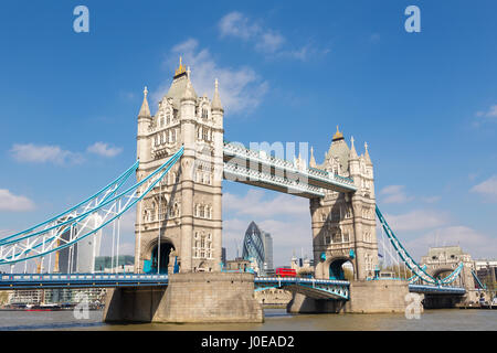 Traditionnel rouge double-decker bus roulant sur le Tower Bridge à Londres, au Royaume-Uni. Gratte-ciel de la ville de Londres en arrière-plan. Banque D'Images