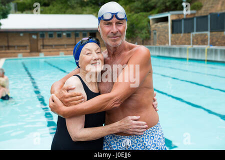 Portrait of smiling senior couple relaxing at poolside Banque D'Images