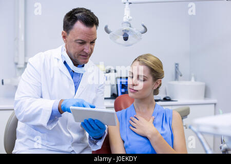 Dentiste au cours digital tablet with female patient dans une clinique dentaire Banque D'Images