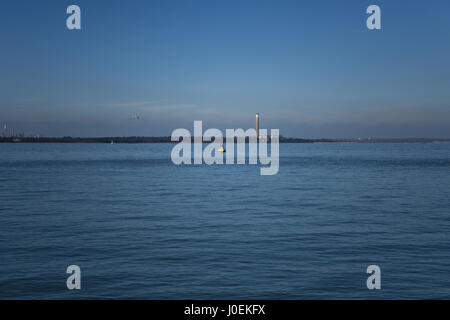 Eaux calmes et de ciel bleu, une vue sur le Solent de l'île de Wight, célèbre pour la semaine de Cowes régate. Station d'alimentation hors service. Banque D'Images