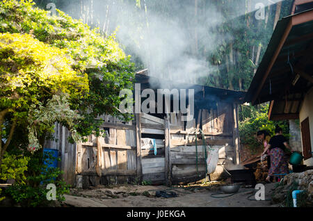 Femme Hmong ethniques et à plumer les poulets à cuisson en plein air matin à Doi Pui Village tribal et National Park le 28 décembre 2016 à Chiang Mai, Banque D'Images