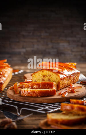 Un gâteau aux fruits confits avec le zeste d'orange sur la planche à découper en bois Banque D'Images