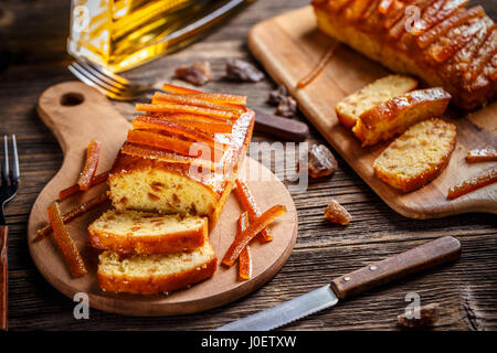 Gâteau avec le zeste d'orange confite sur planche à découper en bois Banque D'Images