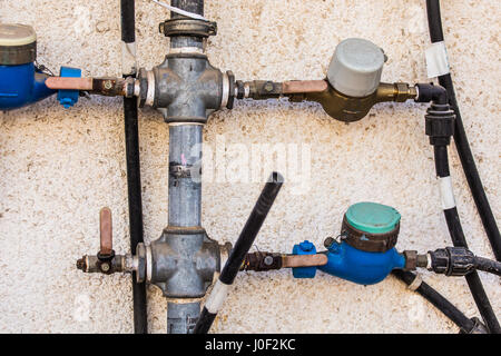 Les compteurs d'eau, les équipements sanitaires sur fond sombre. Banque D'Images