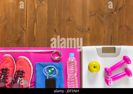 Balances, chaussures et équipement de sport sur le plancher en bois dans la partie inférieure du cadre Banque D'Images