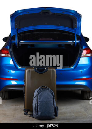 Valises debout à côté d'ouvrir car trunk isolé sur fond blanc Banque D'Images