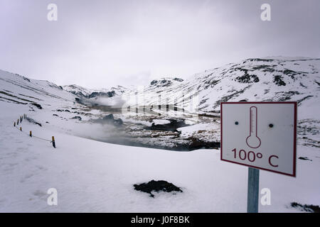 Un panneau d'avertissement de température par les sources chaudes de la géothermie, un populaire de Reykjadalur sentier de randonnée dans les montagnes près de Reykjavik, Islande Banque D'Images