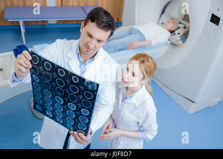 Professionnel sérieux médecin examinant les CT scans du cerveau Banque D'Images