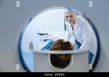 Il sera rapide. Gai friendly médecin professionnel regardant son patient et souriant tout en se préparant pour son examen médical Banque D'Images