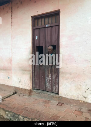 Trinidad, Cuba - 12 Jan 2017 : Vieil homme, regardant à travers une porte dans le vieux Trinidad, Cuba, site du patrimoine mondial de l'UNESCO. Banque D'Images