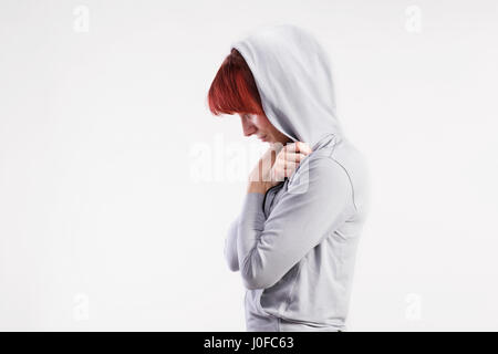 Attractive young woman in fitness sweat gris à capuche. Studio shot sur fond gris. Banque D'Images