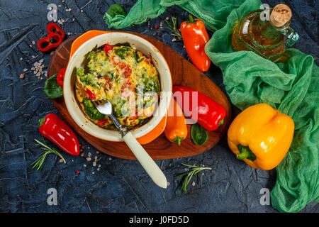 La Frittata avec le brocoli, les épinards, les poivrons et les tomates dans un plat de cuisson en céramique. Omelette italienne aux légumes. Vue d'en haut Banque D'Images