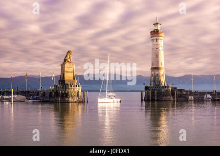 Un voilier entre dans le le port de Lindau, sur le lac Bodensee, au coucher du soleil Banque D'Images